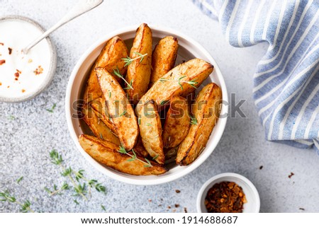 baked potato wedges with sauce on a light background, top view Royalty-Free Stock Photo #1914688687