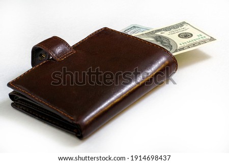 hundred-dollar bills sticking out of a leather purse. High quality photo