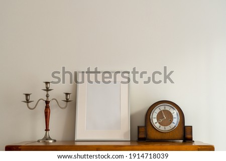 Still life of Oak Cupbaords and top with Silver Picture frame Mock up and antique  wooden and silver candle stick  and old mechanical wind up clock