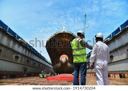Engineering Shipyard working in dry dock yard The bulk carrier general cargo ship in dry dock yard, recondition of hull repairing and repainting,   Royalty-Free Stock Photo #1914730204