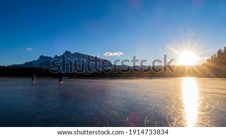 Beautiful view of people ice-skating on the Two Jack Lake in Banff national park, Canada