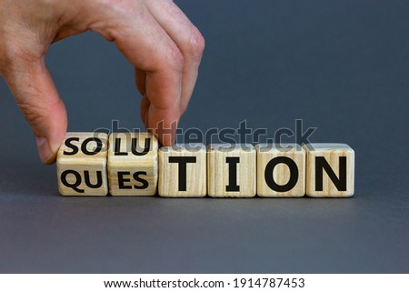Question and solution symbol. Businessman turns wooden cubes and changes the word 'question' to 'solution'. Beautiful grey table, grey background, copy space. Business, question and solution concept. Royalty-Free Stock Photo #1914787453
