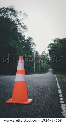 orange traffic cone It is used for warning do not enter car on country road in Thailand.