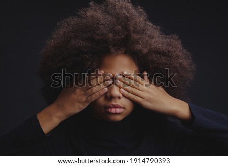 Dramatic portrait of teenage girl is covering eyes with her palms against dark background. Don’t want to see. Social issue concept Royalty-Free Stock Photo #1914790393