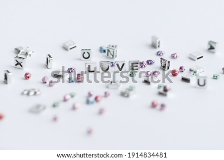 Light photo.On a white background, beads in the form of letters, the letters are made up of the words love, love, no. To use for decoration
