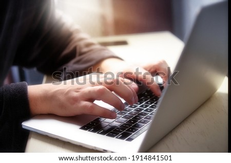Hand typing on computer keyboard. Male hands with laptop. Man in a housecoat working remote at home. Online courses. With blur and shallow depth of field Royalty-Free Stock Photo #1914841501