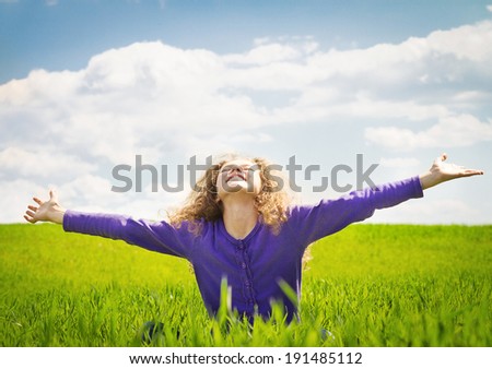 Landscape, picture, portrait very emotional, happy little girl with arms outstretched, looking up to blue sky meadow sunny day, isolated background green grass, clouds. Positive human emotion reaction