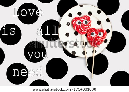 Valentines day greeting card or pattern with two heart shaped candies with eyes on a dotted background