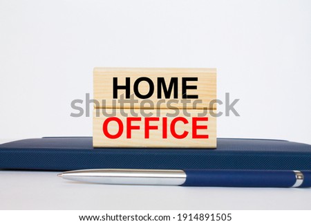 The text Home Office on a wooden blocks, lying on a Notepad with a metal blue pen. Business concept photo