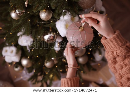 Woman decorating Christmas tree at home, top view