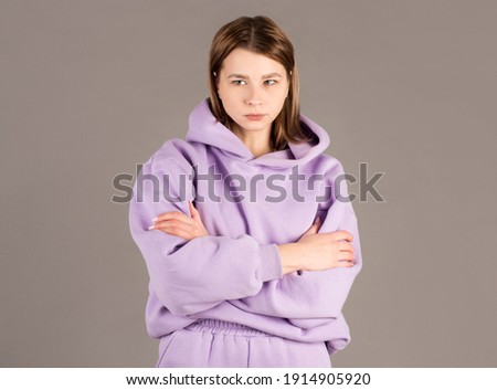 Indoor shot of angry grumpy young female dressed casually keeping arms folded, looking at camera with strict and skeptical expression, doesn't believe excuses of her unfaithful boyfriend