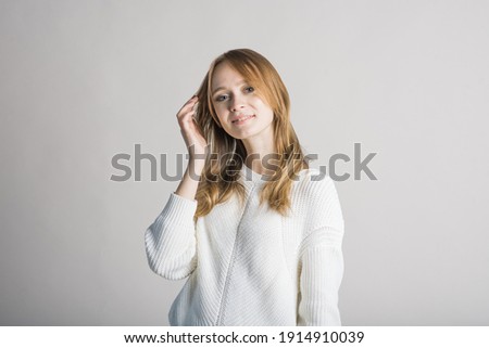 Portrait of a stylish and smiling girl on a white background in the studio