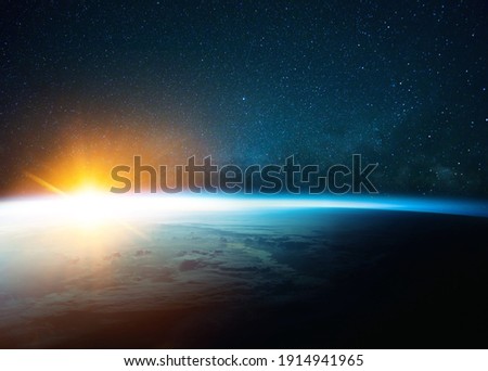 Beautiful blue planet earth in outer space on background of stars and milky way with sunrise. Amazing yellow sunset from space. World with sunlight