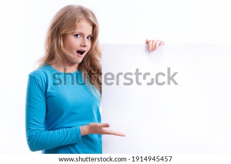 beautiful blond girl with mouth open in wonder, holding an empty white board ready to be filled with some text