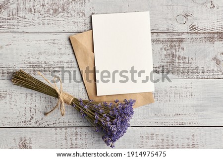 Flat lay with empty greeting card with envelope and lavender flowers