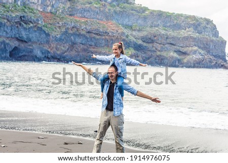 Happy family standing on the beach on the dawn time