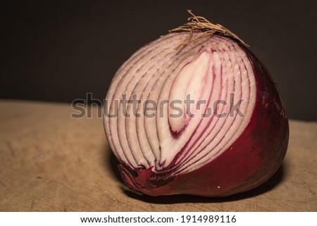Color photo of a red onion sliced in half on a kitchen worktop