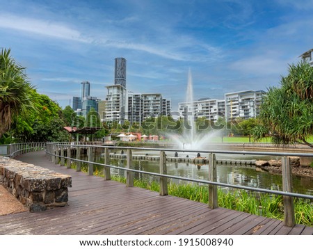 Park lands and apartment building at Roma Street in Brisbane, Australia. Fountain and lake, residential and office buildings in the background, during a bright day of summer. Royalty-Free Stock Photo #1915008940