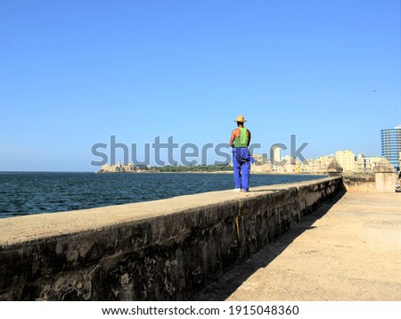 Man fishing on a parapet in Havana, Cuba Royalty-Free Stock Photo #1915048360