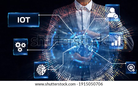 Internet of things - IOT concept. Businessman offer IOT products and solutions. Young businessman  select the abstract chip with text IoT on the virtual display.     