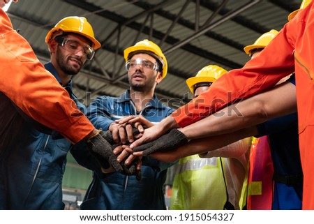 Skillful worker stand together showing teamwork in the factory . Industrial people and manufacturing labor concept . Royalty-Free Stock Photo #1915054327