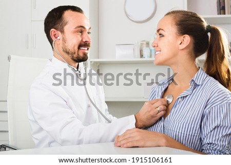 Smiling woman client with male doctor in medicine center