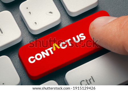 Close up index finger pressing  computer key with contact us word. Customer support concept.
