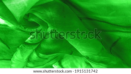 Green fabric with streaks of gray spots on a green background. Abstract designer fabric fancy designer. Beautiful background for your design. Texture. Picture. drawing, pattern, figure
