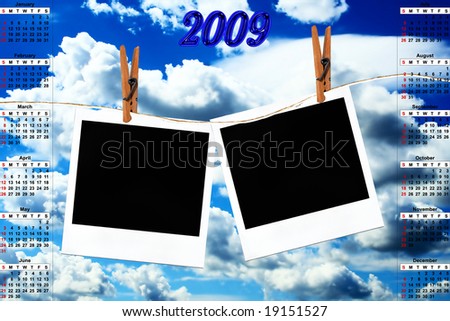 Calendar for 2009 and photos hanging on a rope with clothespins against blue sky