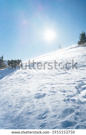 Blowing snow over snowy surface on top of mountain in Switzerland - snowstorm