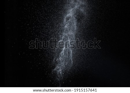 Water splash, spray jet, drops isolated on black background. A splash of water is like lightning, a thunderstorm or the milky way of space. Perfect design element for your photos Royalty-Free Stock Photo #1915157641