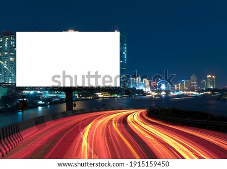 Blank billboard on the highway with a background blur of city. With clipping path on screen - can be used for trade shows, and advertising or promotional poster for you.