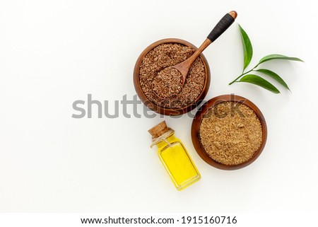 Flaxseeds in a spoon and bowl with a bottle of flaxseed oil and flaxseed flour Royalty-Free Stock Photo #1915160716