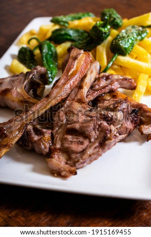 Grilled lamb ribs. Meat served with French fries and peppers. Vertical picture