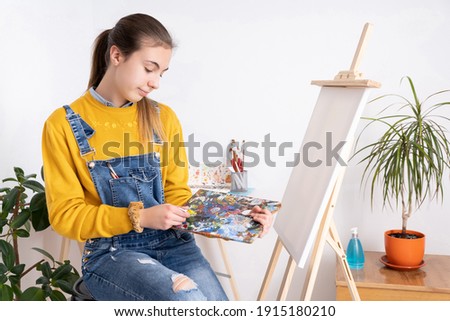 Female artist painting in workshop, white background