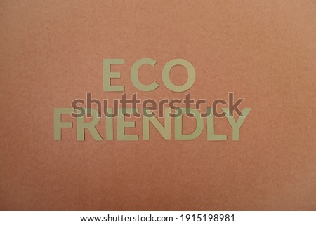Eco Friendly green cardboard letters on a craft paper background. Ecology concept