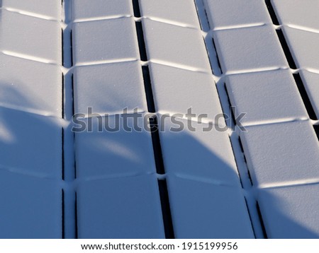 Photovoltaic system on a flat roof totally covered with snow