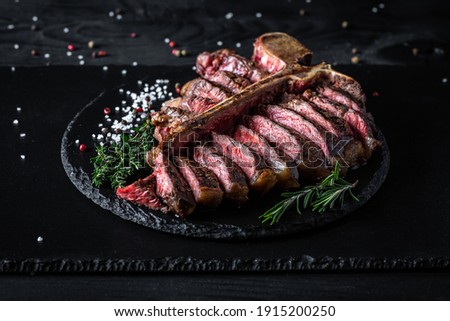 Barbecue Wagu T-Bone Steak. porterhouse grilled beef steak Medium rare with spices on a black table, banner, catering menu recipe place for text, top view. American meat restaurant. Royalty-Free Stock Photo #1915200250