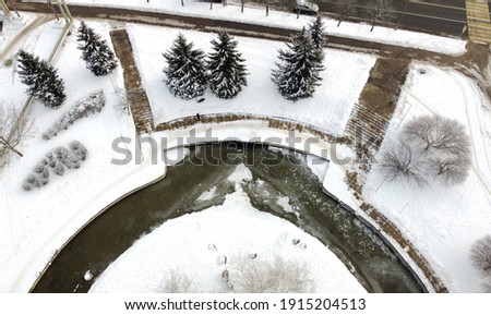 Top view of winter city park with river