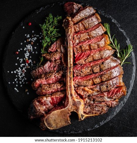 Barbecue Wagyu T-Bone Steak sliced. porterhouse grilled beef steak Medium rare on stone table. American meat restaurant. square image, top view. Royalty-Free Stock Photo #1915213102
