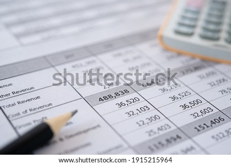 Accounting business concept. Calculator with accounting report and financial statement on desk. Royalty-Free Stock Photo #1915215964