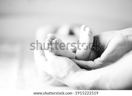 
Dad holds baby's feet in his hands Royalty-Free Stock Photo #1915222519