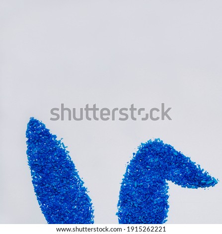  Happy Easter with blue colored coconut flakes bunny ears On white Background. Easter concept. Minimal concept. Sweet candy concept. Flat lay. Copyspace for text. Easter banner, card.                 