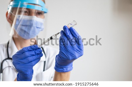 female doctor preparing to give coronavirus vaccine