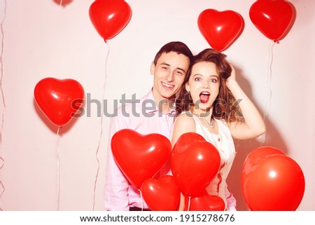 Man with his lovely sweetheart girl dance and have fun at Lover's valentine day. Valentine Couple Party. Background red balloons hearts. Love concept. Crazy.  Royalty-Free Stock Photo #1915278676