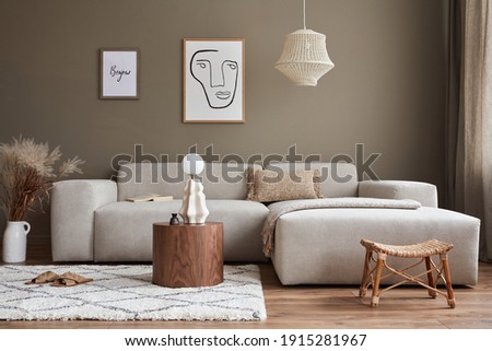 Interior design of stylish living room with modern neutral sofa, mock up poster farmes, dried flowers in vase, coffee tables, decoration and elegant personal accessories in home decor. Template. Royalty-Free Stock Photo #1915281967