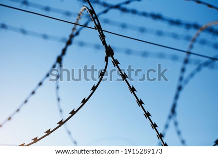The clear blue sky is chained with barbed wire - the steel shackles of freedom