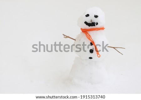 Little snowman with an orange scarf.