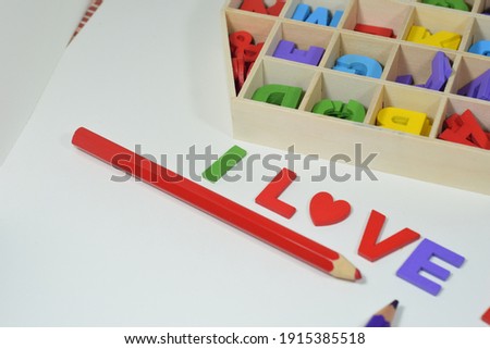 'I LOVE YOU' Wording,Colour Pencils and A Wooden Alphabet Organiser Box Isolated With White Background