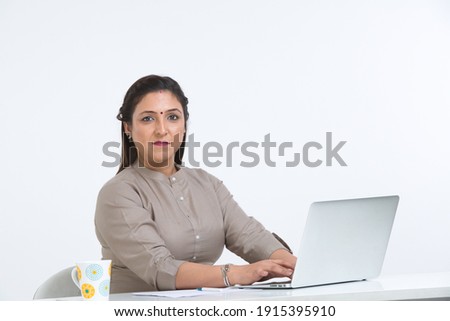 Businesswoman using laptop over white background.